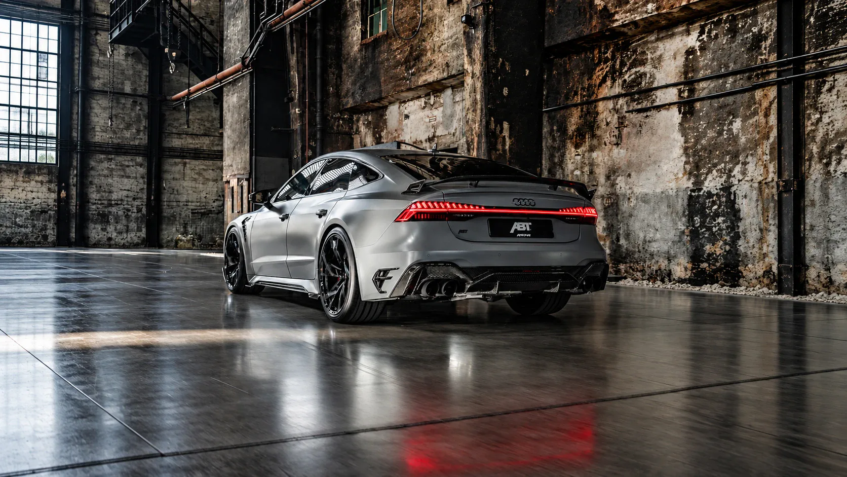 Grauer Audi RS 7 in einer Industriehalle mit leuchtendem Rücklichtband